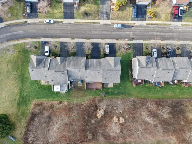 an aerial view of a house with a yard and basket ball court