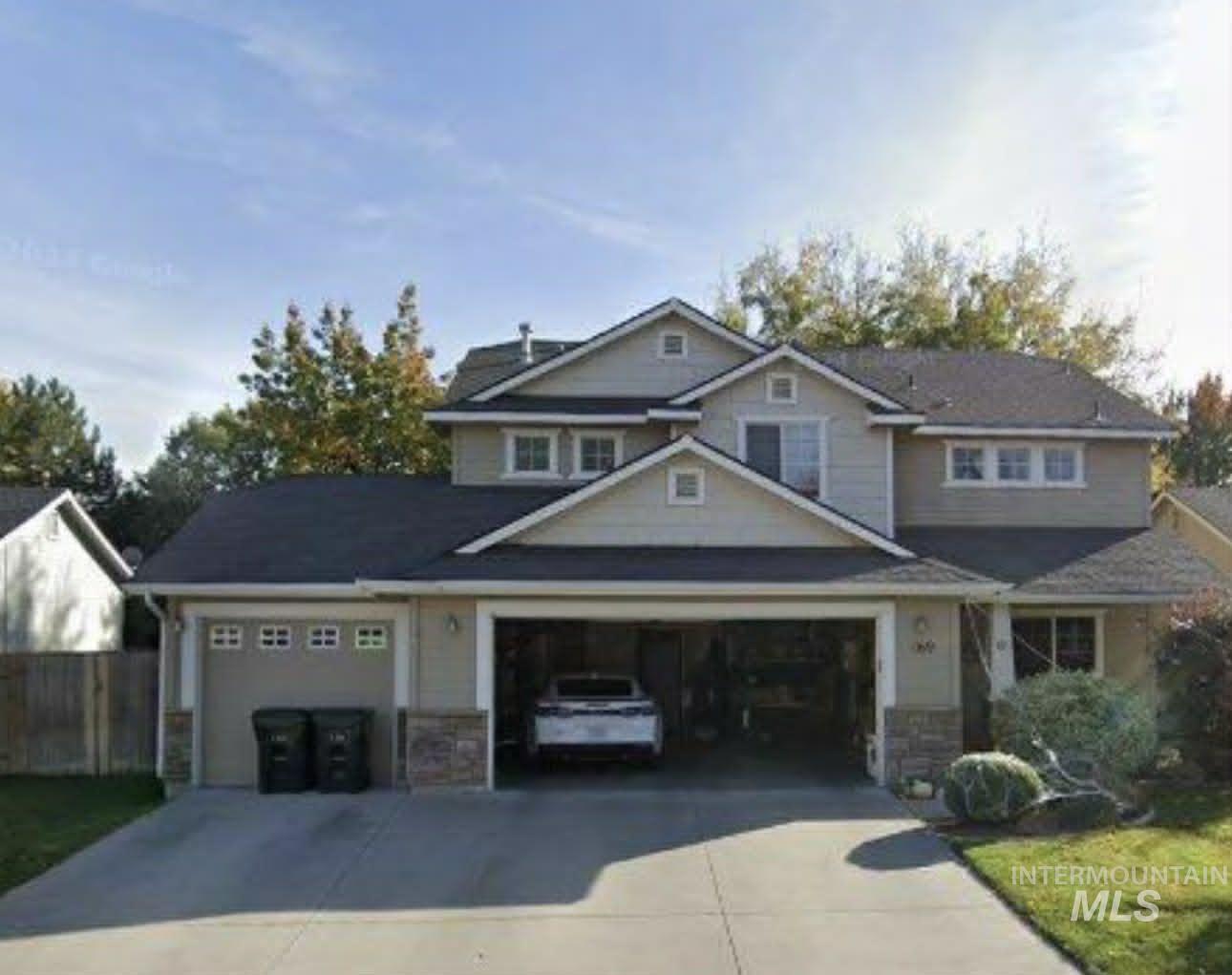 Craftsman-style house featuring stone siding, concrete driveway, and an attached garage