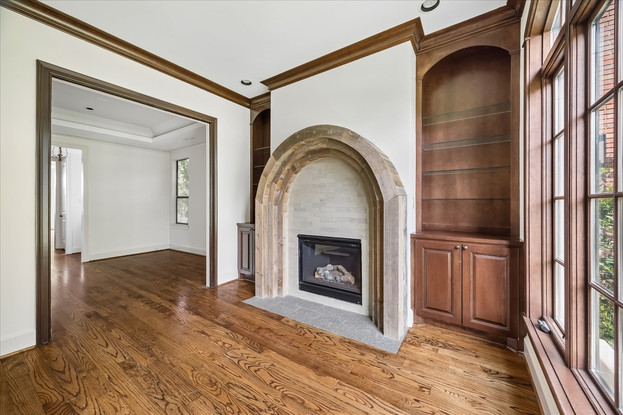 2246 Branard Street Houston, TX 77098 - Photo 7 of 40 Arched fireplace detail and rich cabinetry anchor the den, with seamless flow to the adjacent dining room.