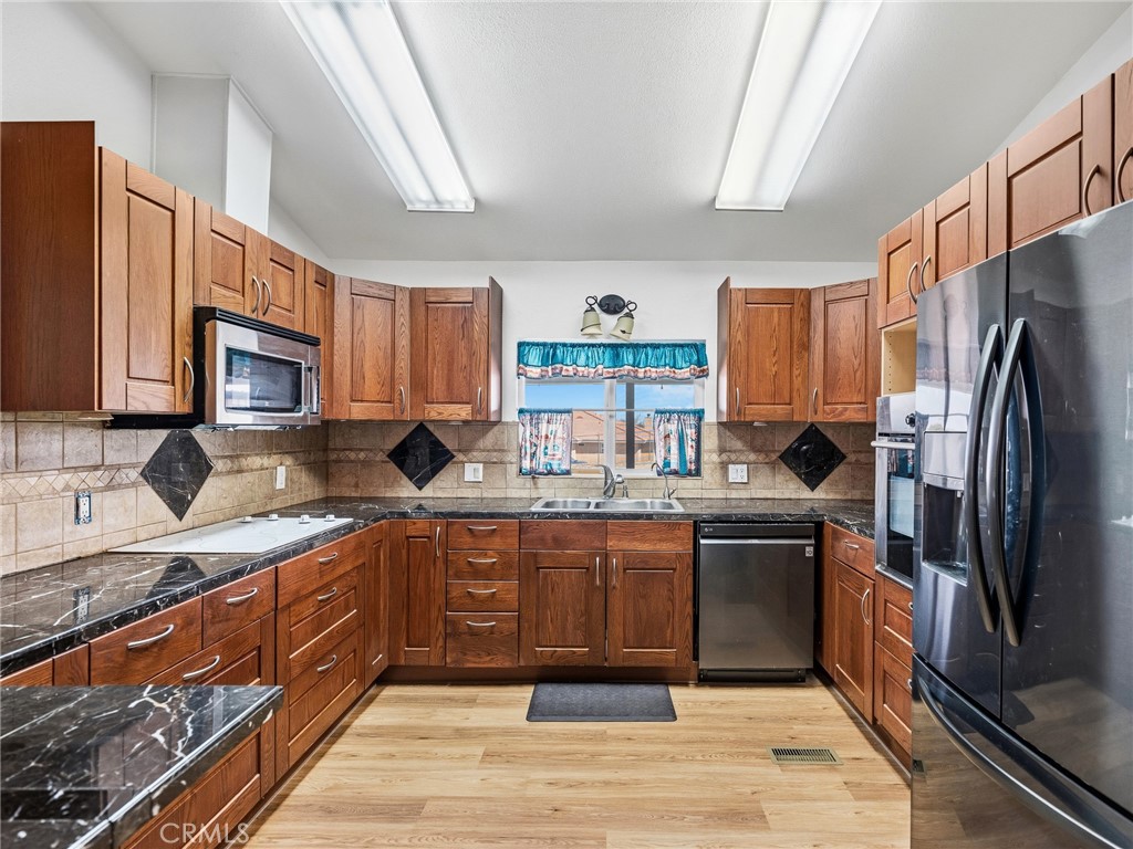 599 Smoke Tree Road Pinon Hills, CA 92372 - Photo 11 of 34 a kitchen with stainless steel appliances granite countertop a refrigerator stove a sink and dishwasher