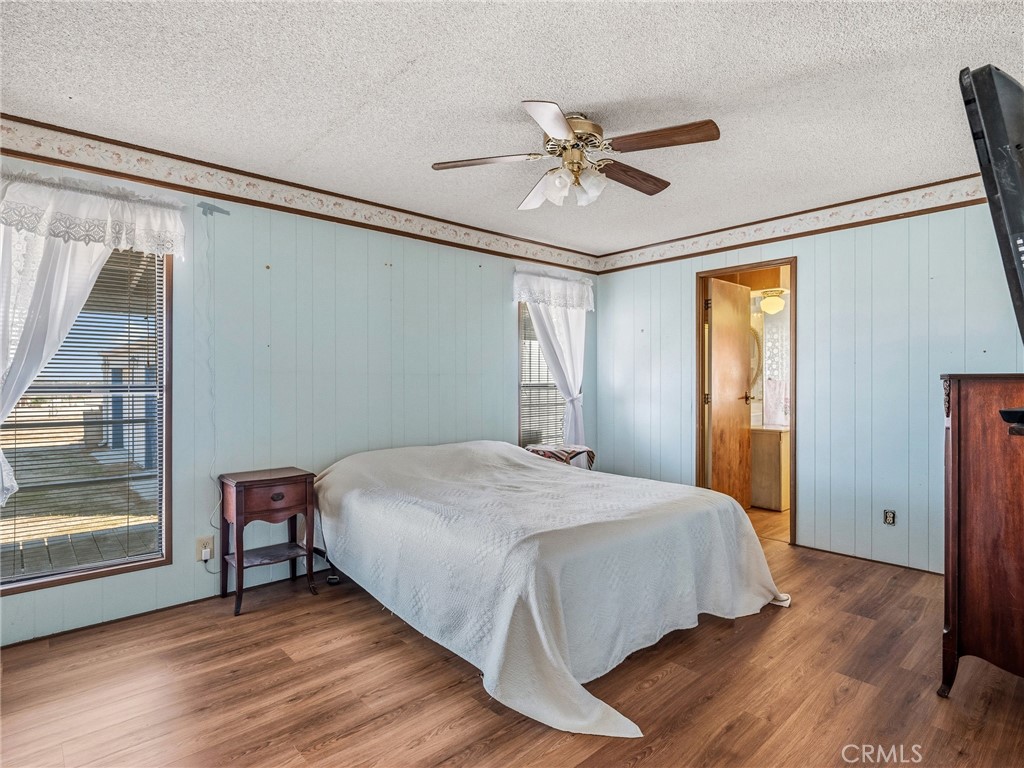 599 Smoke Tree Road Pinon Hills, CA 92372 - Photo 16 of 34 a bedroom with a bed and wooden floor
