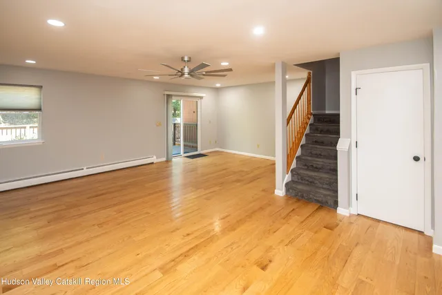 an empty room with wooden floor and staircase