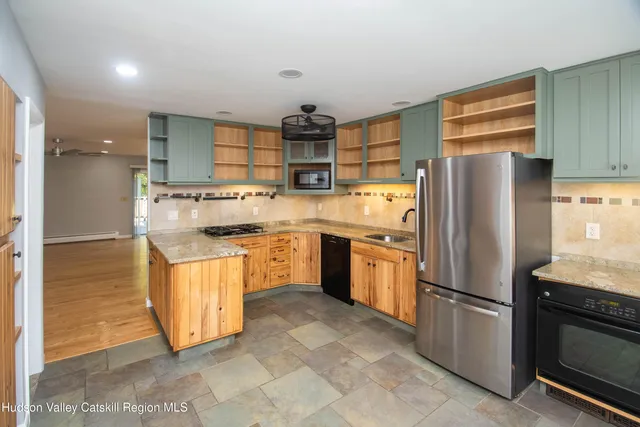 a kitchen with stainless steel appliances granite countertop a refrigerator a stove and a sink
