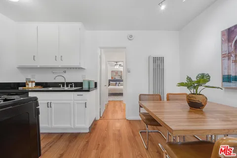 a kitchen with stainless steel appliances potted plants and white cabinets