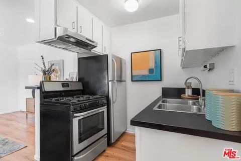 a kitchen with stainless steel appliances granite countertop a sink stove and cabinets