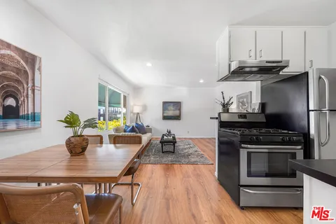 a kitchen with stainless steel appliances a stove a sink dishwasher and cabinets with wooden floor