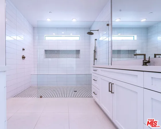 a large bathroom with a large mirror vanity and shower