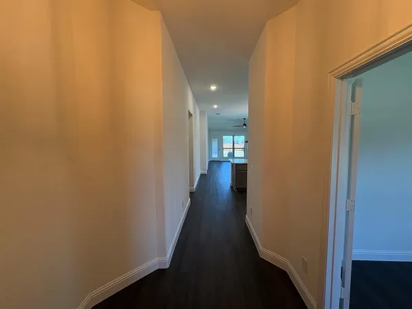 a view of a hallway with wooden floor