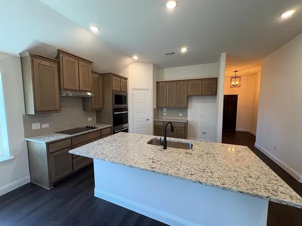 a kitchen with stainless steel appliances granite countertop a sink refrigerator and microwave