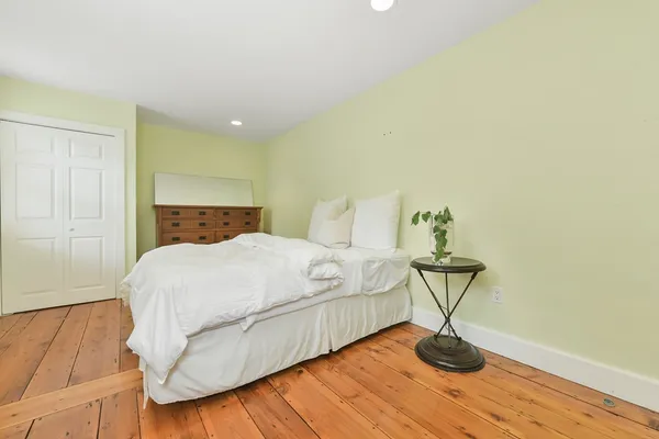 a bedroom with a bed and wooden floor