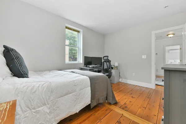 a bedroom with a bed and wooden floor