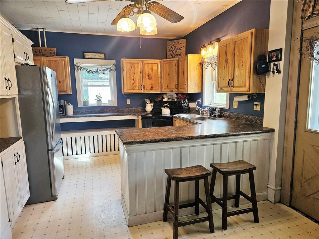 175 Blackfield Road Garrett, PA 15542 - Photo 5 of 37 a kitchen with a refrigerator a sink dishwasher a dining table and chairs with wooden floor