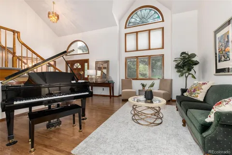 a living room with furniture a rug a potted plant and a window