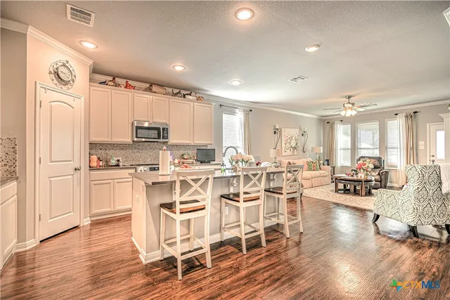 a kitchen with stainless steel appliances a stove a refrigerator cabinets and wooden floor