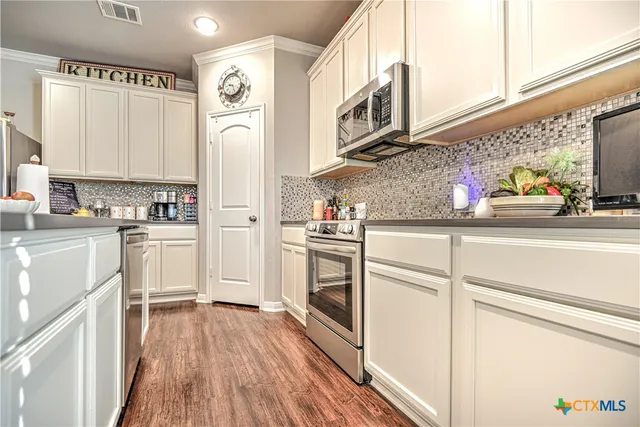 a kitchen with white cabinets and white appliances