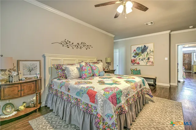 a bedroom with a bed a dresser and painting on the wall
