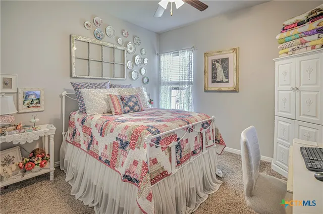 a bedroom with a bed next to a window and a chandelier