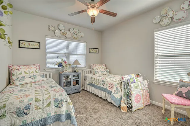 a bedroom with two beds and windows