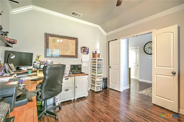 a view of a workspace with furniture and a window