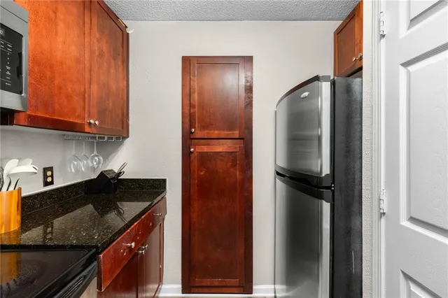 a kitchen with granite countertop a stove and a microwave