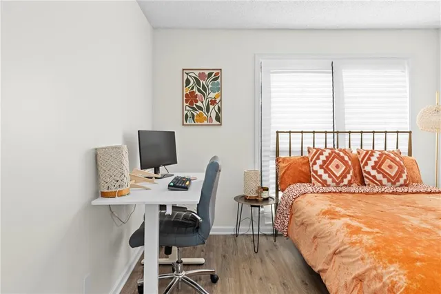 a bedroom with a bed and a flat tv screen on dresser