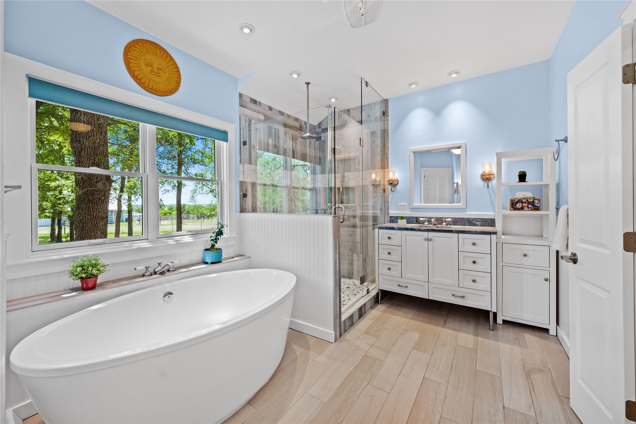7670 Nez Perce Trace Manor, TX 78653 - Photo 13 of 40 Bathroom with a stall shower, vanity, a freestanding bath, and a wealth of natural light