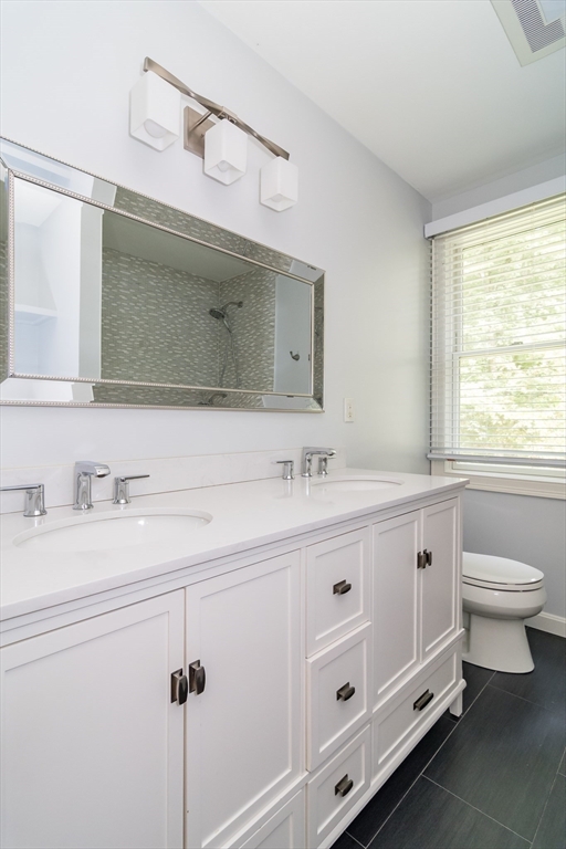 11 Parsons Way Natick, MA 01760 - Photo 17 of 29 a bathroom with a double vanity sink a toilet and a mirror