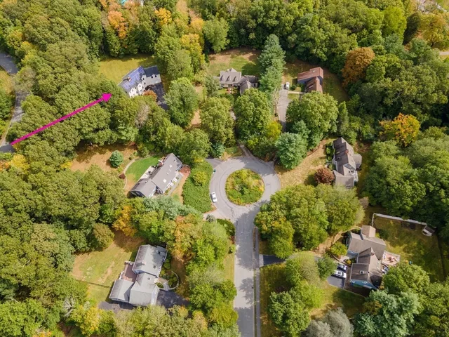an aerial view of residential house with outdoor space and trees all around