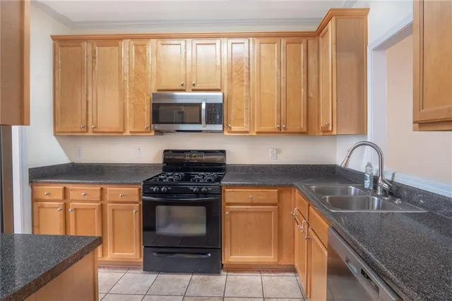 a kitchen with granite countertop a stove a sink and a microwave