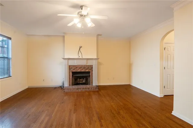 a view of empty room with wooden floor and fireplace