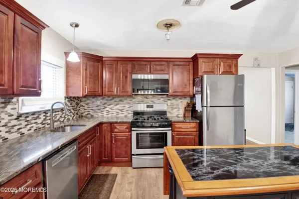 a kitchen with stainless steel appliances granite countertop a stove and a refrigerator
