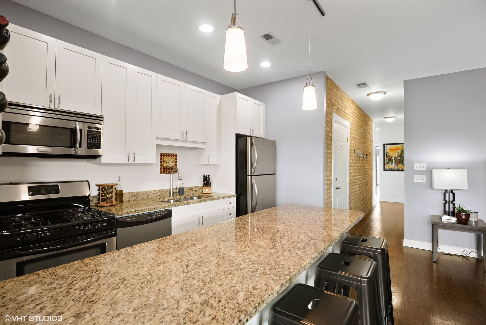 2116 North Spaulding Avenue, Unit 21163 Chicago, IL 60647 - Photo 7 of 18 a kitchen with stainless steel appliances granite countertop a stove and cabinets