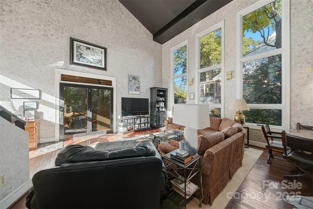 a living room with furniture a flat screen tv and a large window