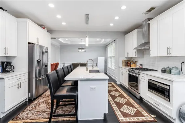 a kitchen with white cabinets and stainless steel appliances