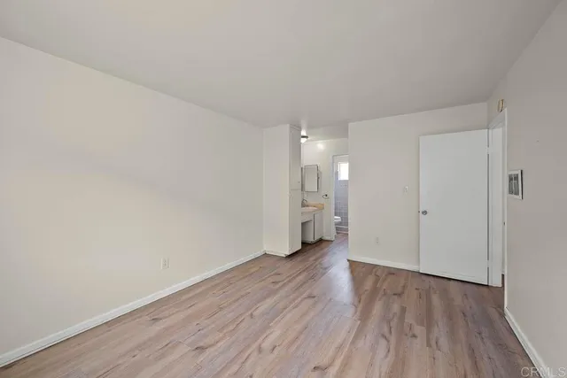 a view of a room with wooden floor and white walls