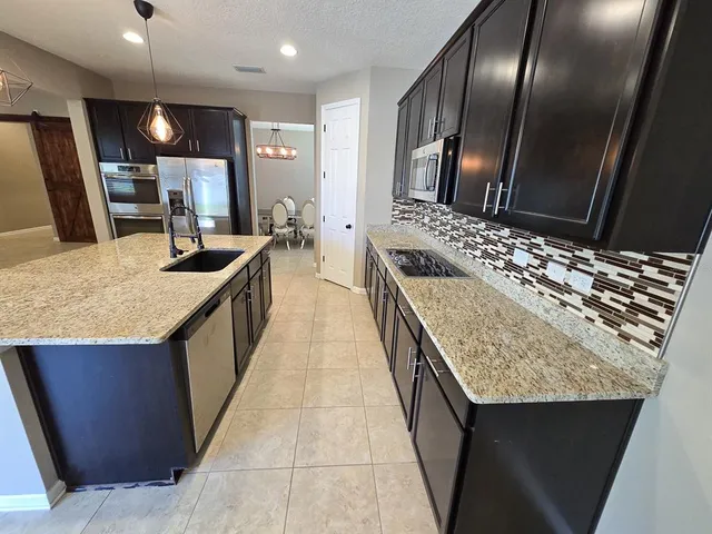 a bathroom with a granite countertop sink and a large mirror