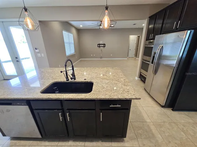 a kitchen with a sink a refrigerator and cabinets
