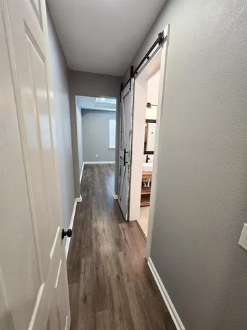 a view of a hallway with wooden floor and staircase