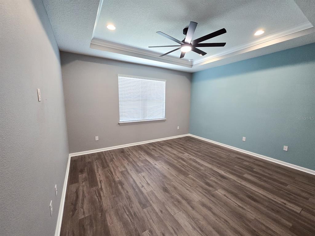 3543 Meadow Breeze Loop Ocoee, FL 34761 - Photo 17 of 38 an empty room with wooden floor ceiling fan and windows