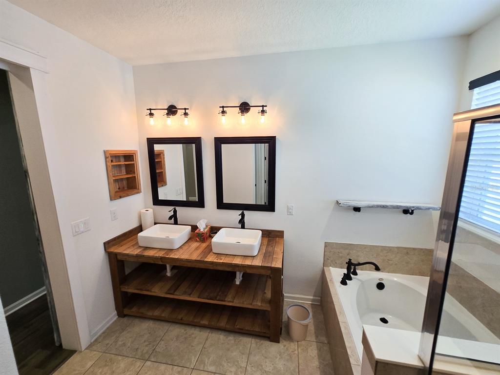 3543 Meadow Breeze Loop Ocoee, FL 34761 - Photo 21 of 38 a bathroom with a bathtub sink and mirror