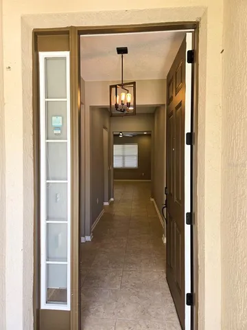 a view of a hallway with a chandelier and dining room view