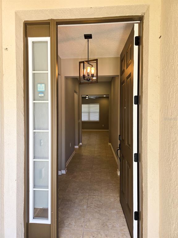 3543 Meadow Breeze Loop Ocoee, FL 34761 - Photo 3 of 38 a view of a hallway with a chandelier and dining room view