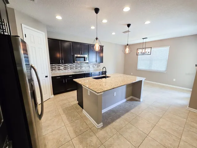 a kitchen with a stove a refrigerator and a sink