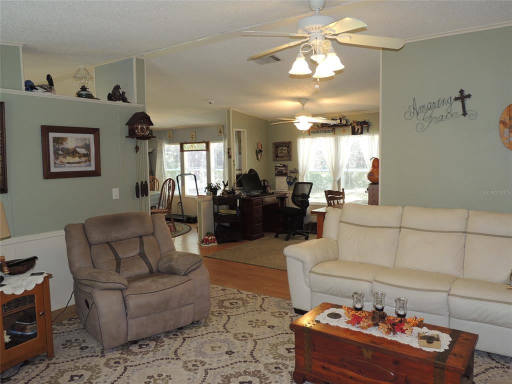 7050 Southeast Co Road 337 Morriston, FL 32668 - Photo 31 of 67 a living room with furniture and a chandelier