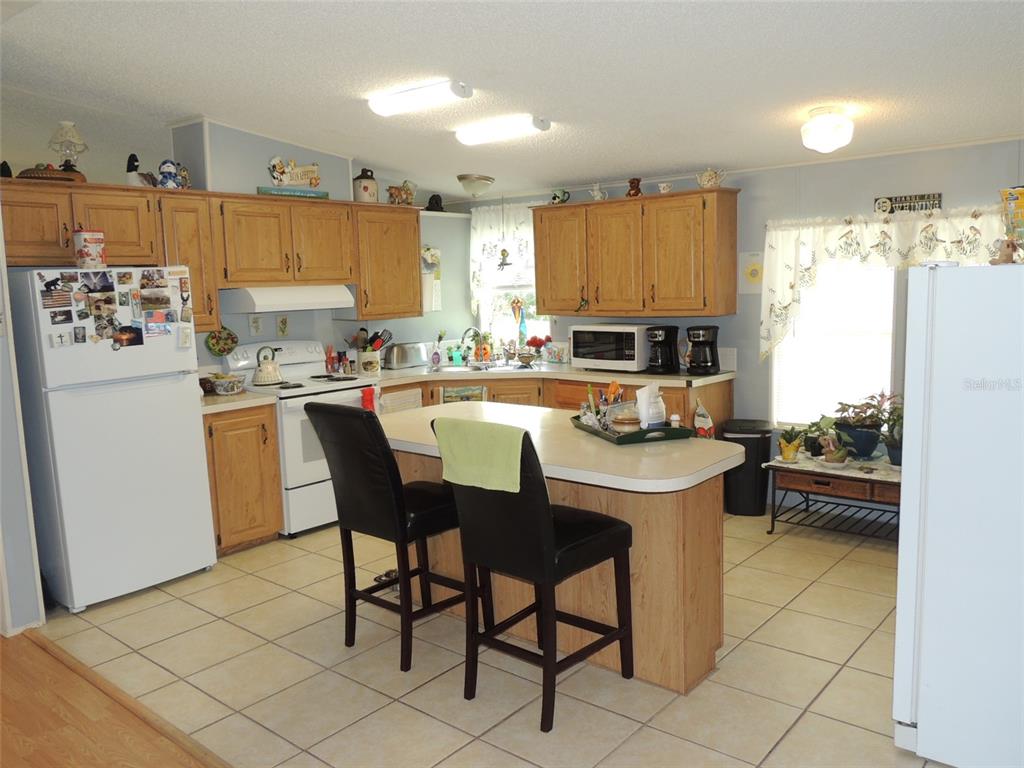 7050 Southeast Co Road 337 Morriston, FL 32668 - Photo 44 of 67 a kitchen with a sink a stove a refrigerator and cabinets