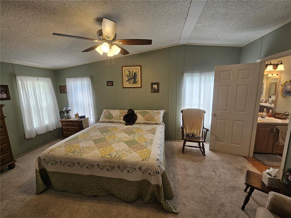 7050 Southeast Co Road 337 Morriston, FL 32668 - Photo 48 of 67 a spacious bedroom with a bed a desk and chair