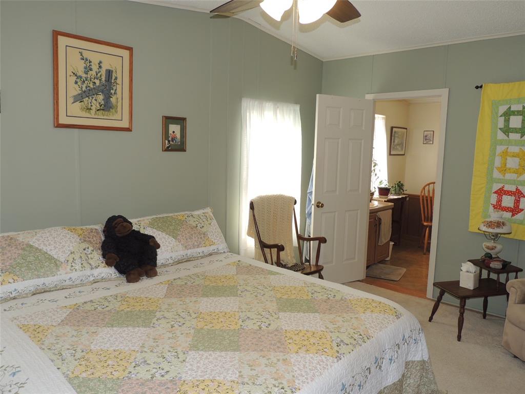 7050 Southeast Co Road 337 Morriston, FL 32668 - Photo 50 of 67 a bedroom with a bed and a chandelier