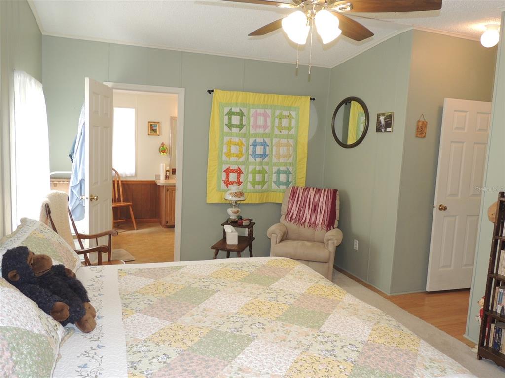 7050 Southeast Co Road 337 Morriston, FL 32668 - Photo 51 of 67 a bedroom with a large bed and a chandelier