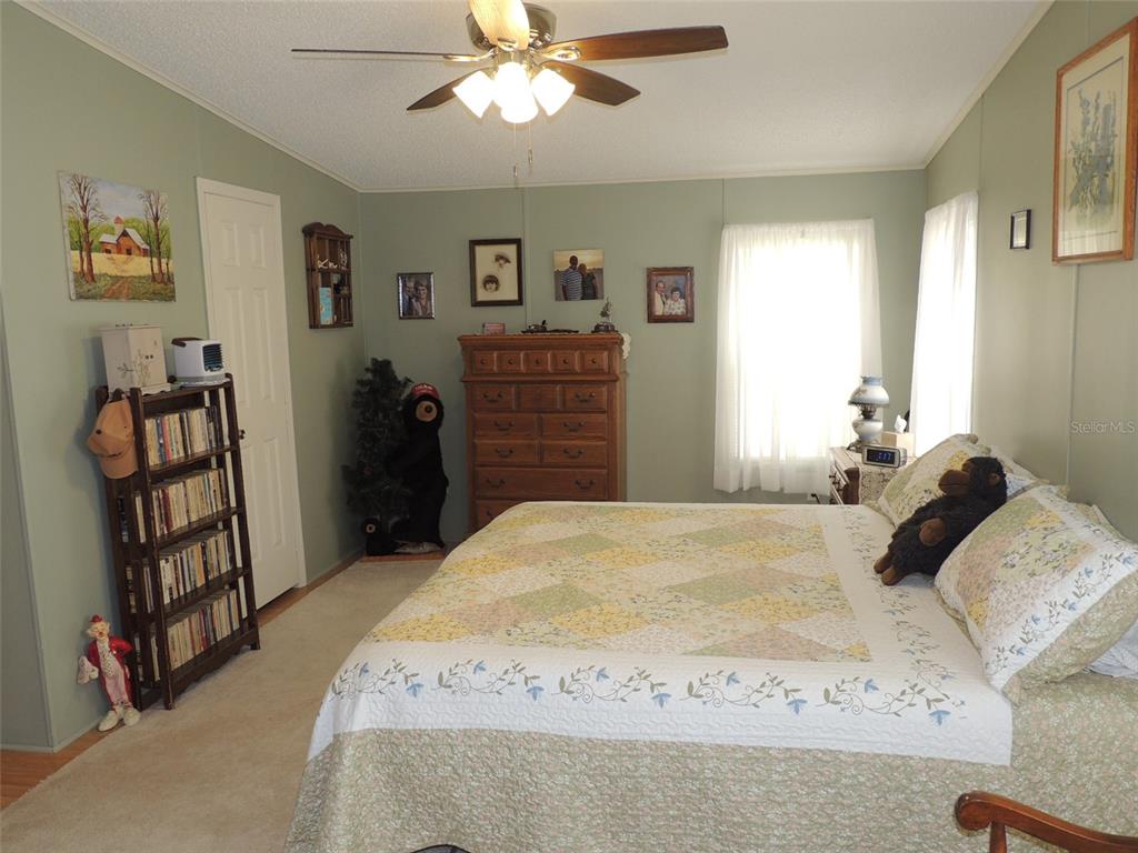 7050 Southeast Co Road 337 Morriston, FL 32668 - Photo 52 of 67 a bedroom with a bed and a chandelier