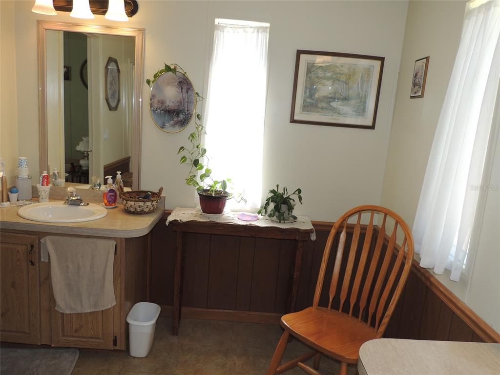 7050 Southeast Co Road 337 Morriston, FL 32668 - Photo 56 of 67 a bathroom with a sink a toilet and mirror
